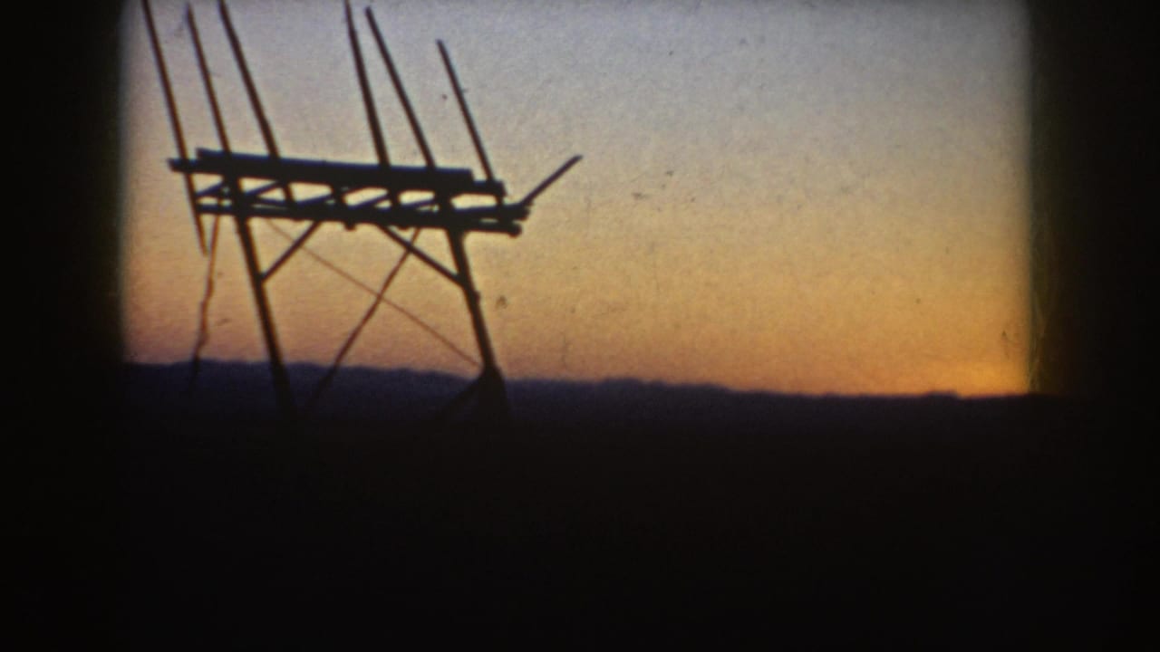 Rural South Dakota 1953 frame showing the antenna structure closer in silhouette, with support rods and a dangling line visible.