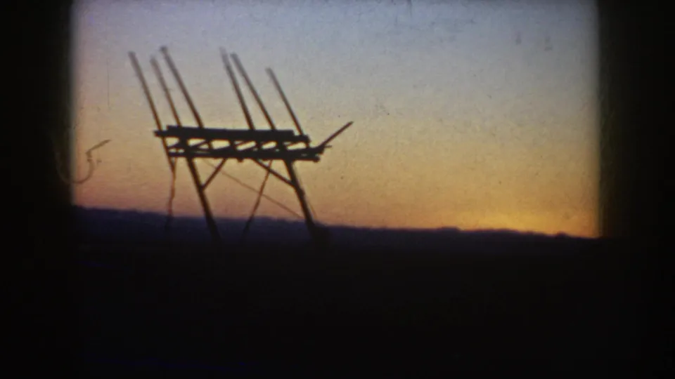 Final 1953 South Dakota 8mm frame showing the antenna-like silhouette against a warm band of sunset near the horizon.