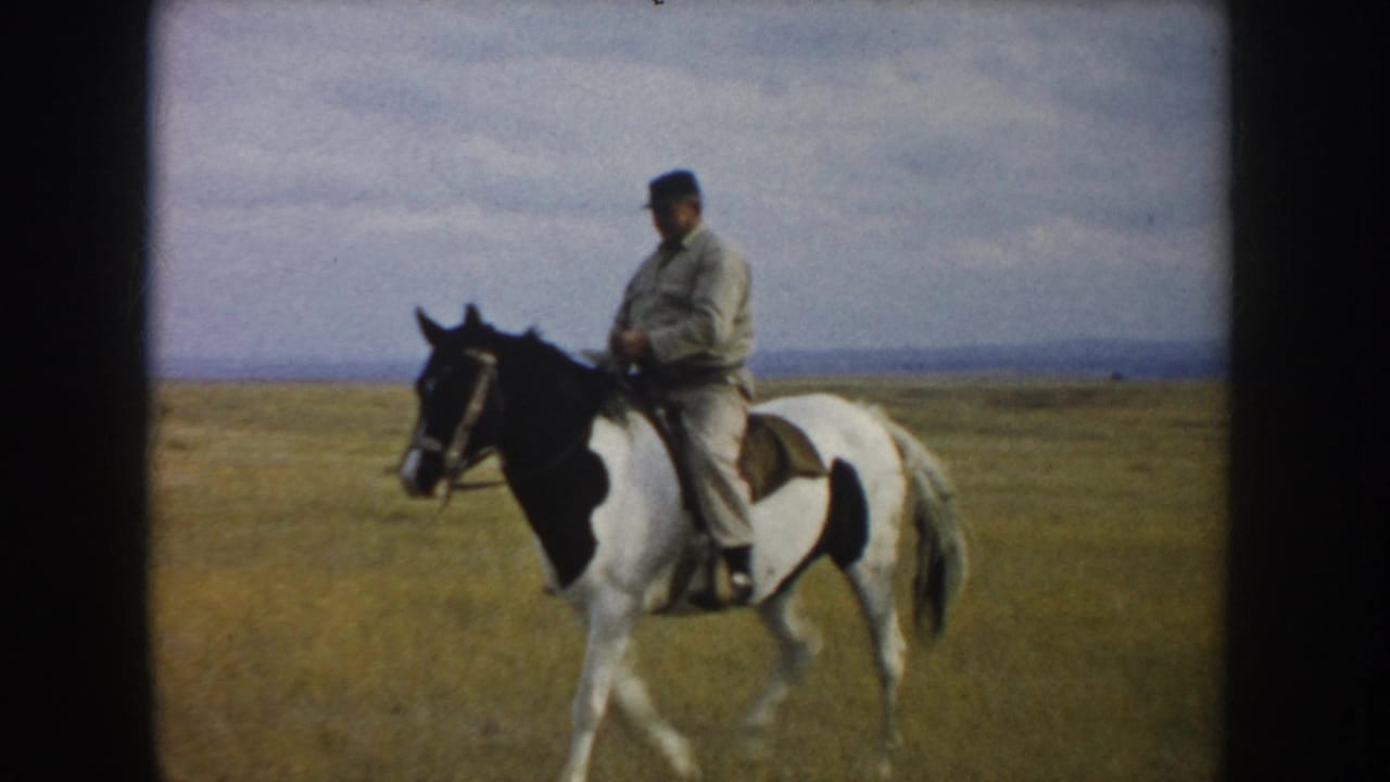 A closer 1953 South Dakota frame shows the rider seated on a pinto horse, with prairie grass, distant hills, and cloudy sky visible.