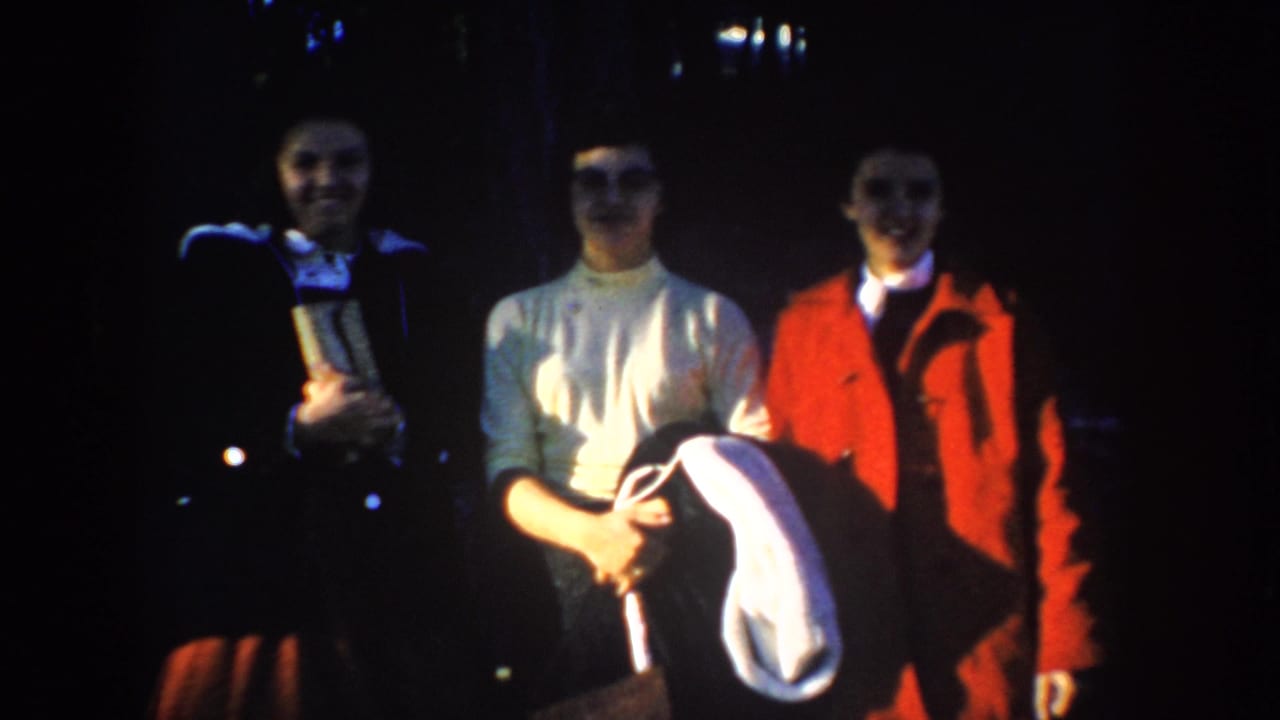 Three young women pose at night at Mount Rushmore, South Dakota, in 1953 home-movie footage.