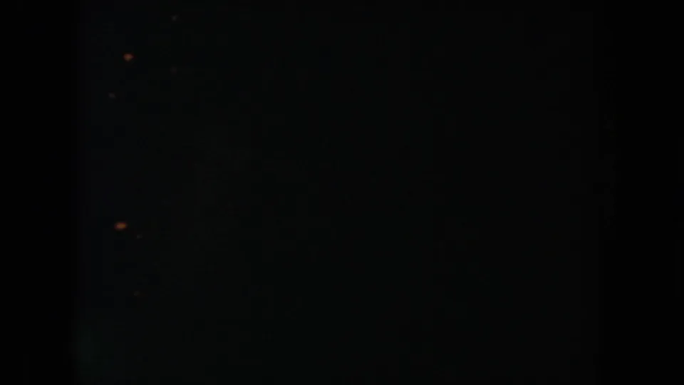 Dark ending frame from the 1954 South Dakota home movie, with minimal visible detail and faint film specks.