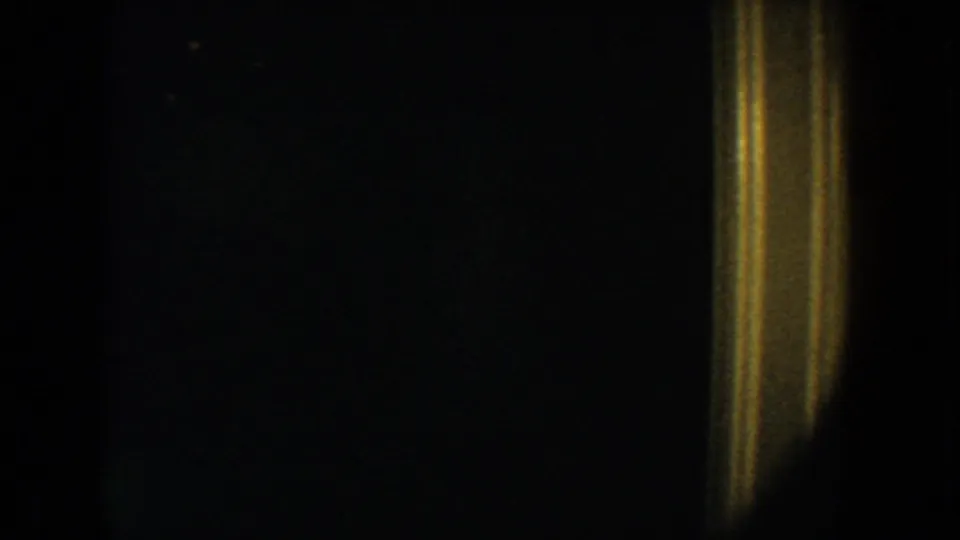 1954 South Dakota 8mm frame showing a dark interior doorway with warm yellow trim and very low visible detail.