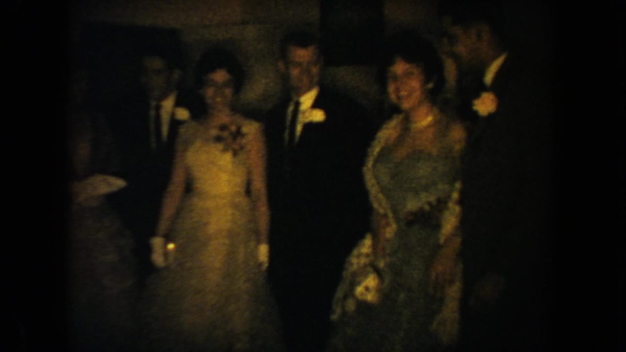 South Dakota 1954 wedding reception guests pause for the camera, with gowns, dark suits, gloves, and boutonnieres visible.