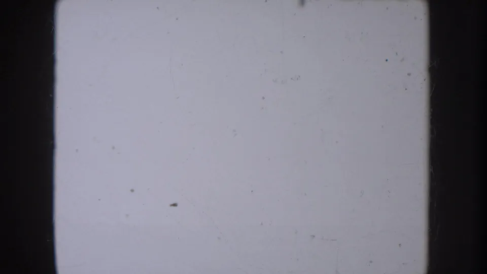 Mostly blank or overexposed 8mm frame from the South Dakota home movie, showing dust, faint scratches and dark film edges.