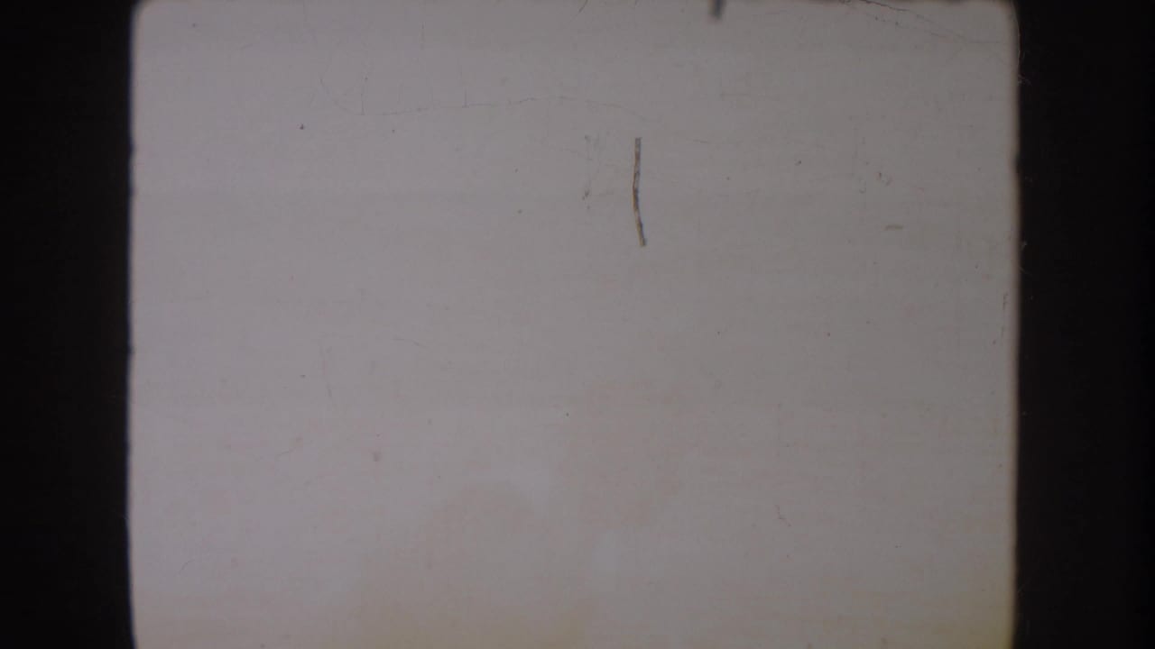 Pale tinted frame with scratches, soft discoloration, and dark film borders.