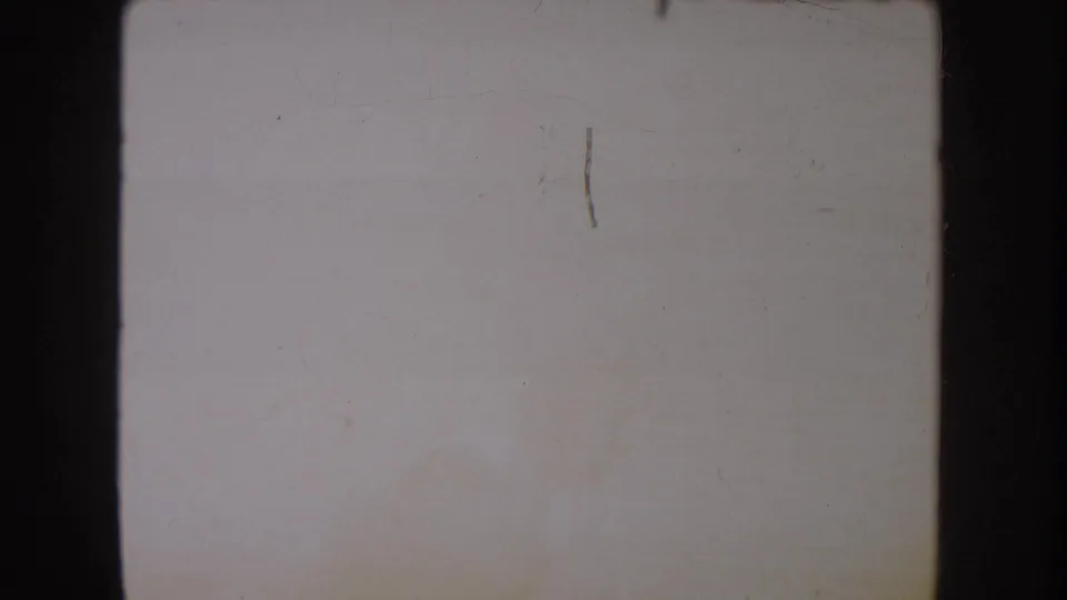 Faded 8mm frame with pale color shift, visible scratches, rounded frame edges, and no clear subject detail.