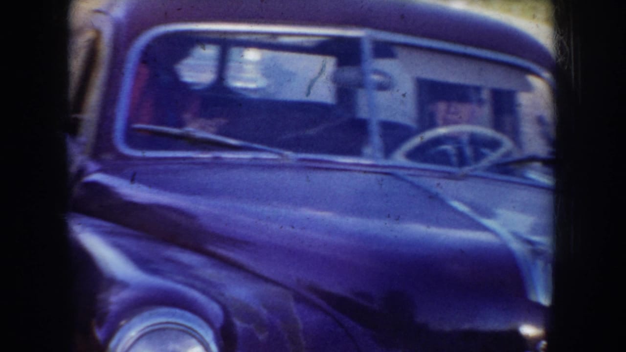 Close view of a dark rounded car seen through a window or doorway frame.