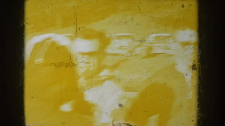 8mm film frame from a circa 1955 reel showing severe yellow chemical fogging, white bleached areas, and ghostly pale impressions consistent with chemical or light degradation of the original film stock.