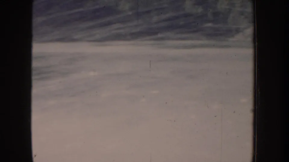 Flat lake water from a 1955 Idaho home movie; extreme color fading produces pale beige-pink tones across the entire frame.