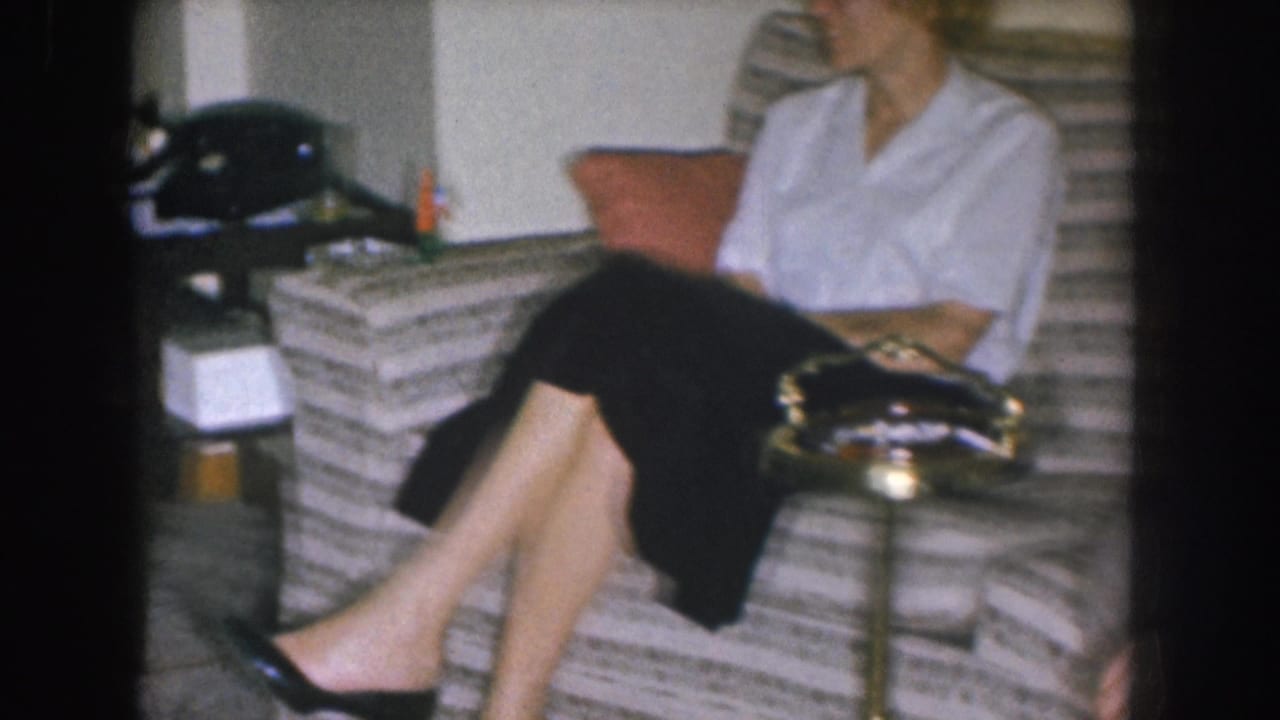 Woman's lower body in black skirt and heeled shoes on a striped couch; rotary phone at left, lamp visible in background, head cropped at frame top.
