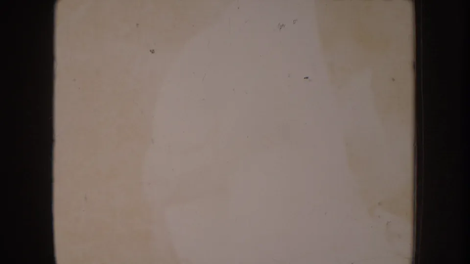 Overexposed transition frame from a circa 1955 8mm home movie; almost no image content visible, showing film bleaching and age-related discoloration.