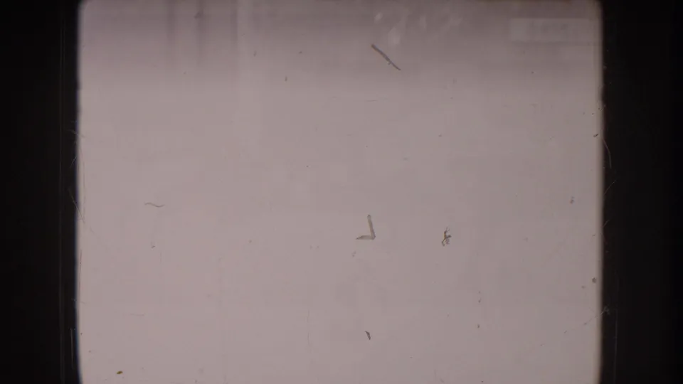 Washed-out frame from a circa 1955 8mm home movie showing scratches, dust marks, and near-total overexposure with faint ghost detail.