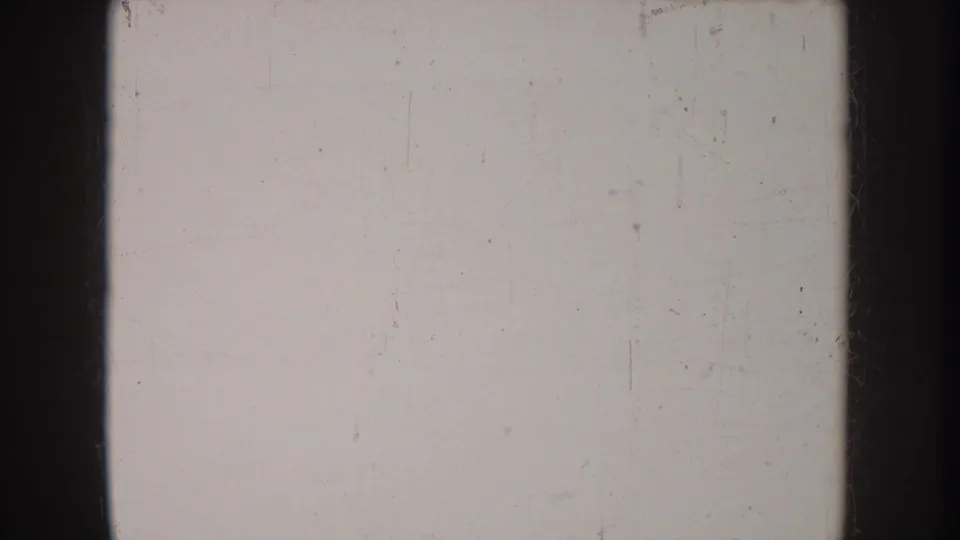 Overexposed or film-flash frame from an 8mm home movie reel, yielding a near-blank white image — a characteristic artifact of vintage amateur footage