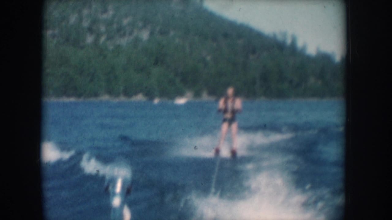 Close view of water skier in swimsuit and life vest on a lake in South Dakota, circa 1956, filmed on 8mm from the tow boat