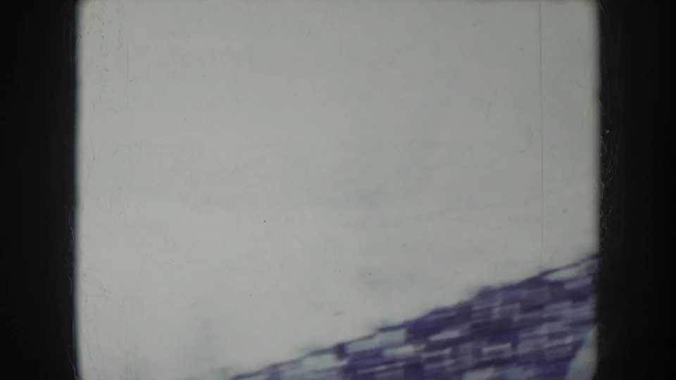 Camera pan sweeps through open sky during the 8mm stadium sequence, leaving a near-blank frame with a sliver of stand structure at the base.