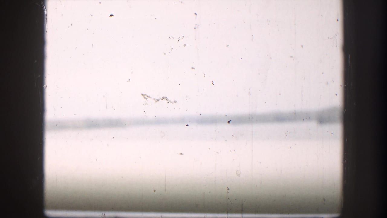 Overexposed opening frame from a 1958 8mm home movie — possibly a title card or a bright outdoor shot — with film dust and barely visible horizontal lines.