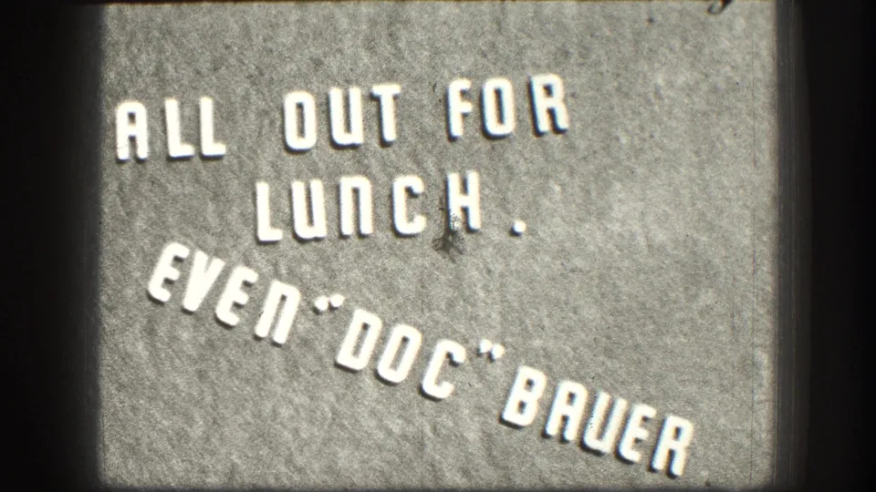 Close-up of a humorous 1950s business sign in white stenciled lettering on a gray concrete or stone surface, Kansas, circa 1958.