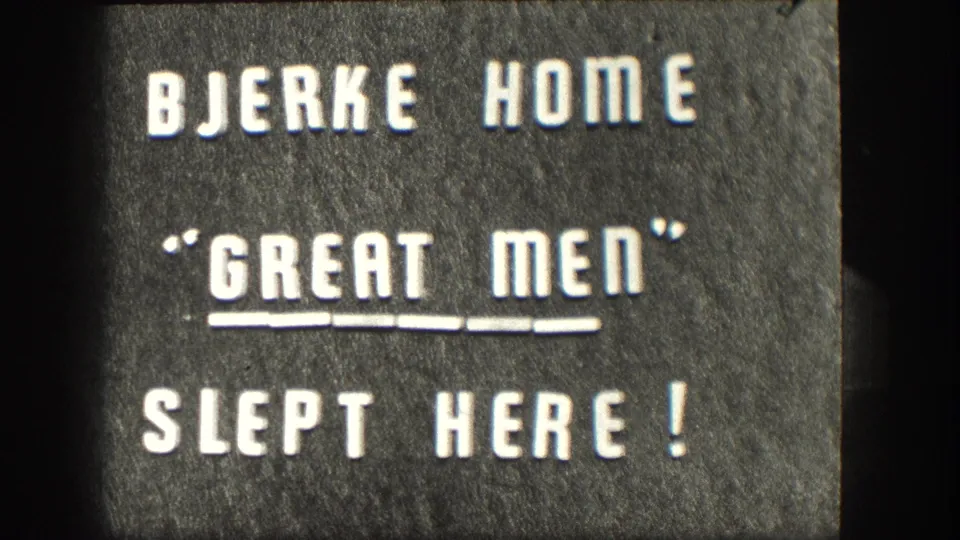 1958 8mm home-movie intertitle card: 'BJERKE HOME / GREAT MEN SLEPT HERE!' white capitals on gray textured background, 'GREAT MEN' underlined with double rule.