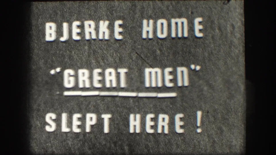 Continued 1958 home-movie intertitle: 'BJERKE HOME / GREAT MEN SLEPT HERE!' white capitals on gray textured background, double underline beneath GREAT MEN.