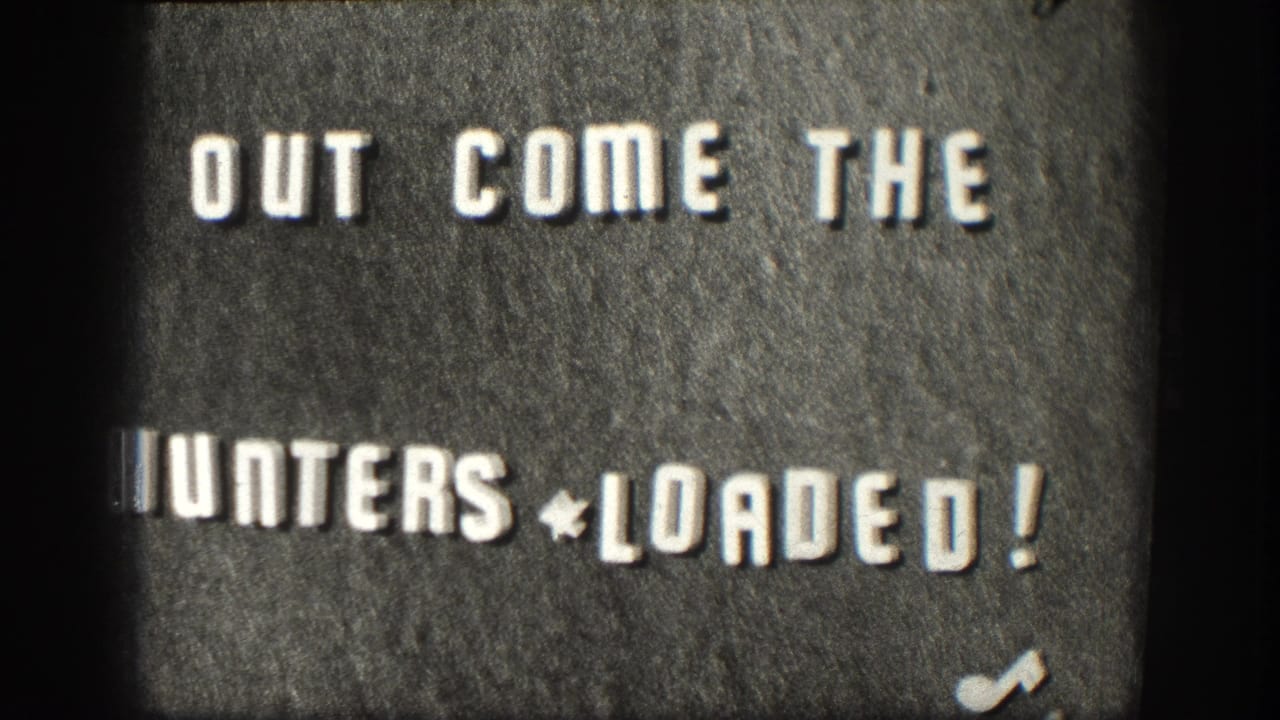 Same title card: white block letters 'OUT COME THE HUNTERS * LOADED!' on dark textured background, slight exposure shift from preceding frame.