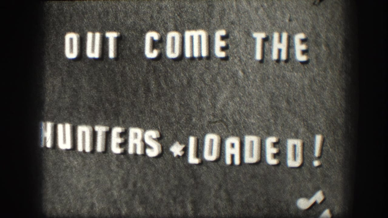 Home-movie intertitle on felt board, circa 1958 Kansas, reading 'OUT COME THE HUNTERS * LOADED!' — a DIY chapter-title card typical of mid-century amateur 8mm film.