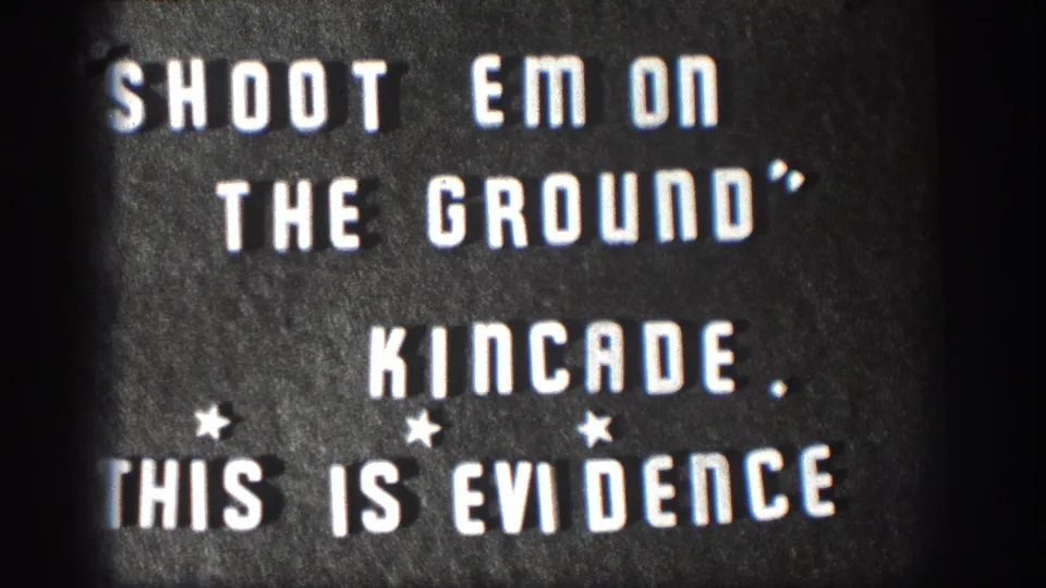 1958 Kansas 8mm home movie title card; white stencil letters read SHOOT EM ON THE GROUND, KINCADE, THIS IS EVIDENCE with three small star decorations and film vignette