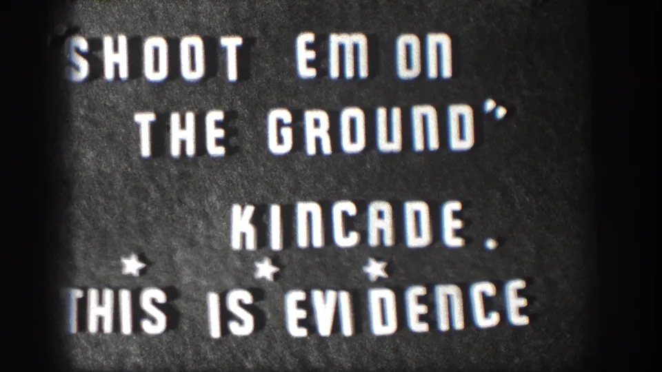 1958 Kansas 8mm home movie title card; white stencil letters read SHOOT EM ON THE GROUND, KINCADE, THIS IS EVIDENCE with star ornaments and film-edge vignette