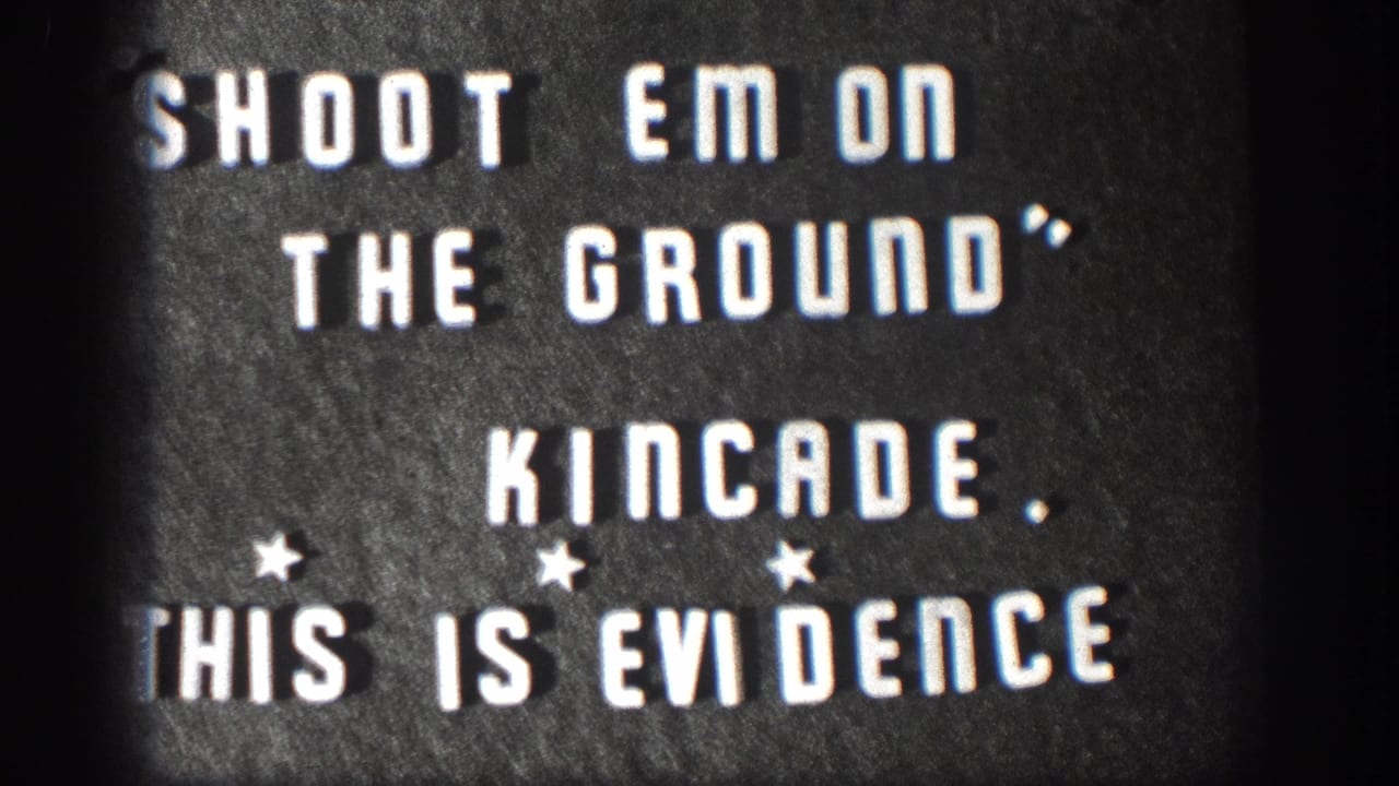 1958 Kansas 8mm home movie title card; white stencil letters on dark board read SHOOT EM ON THE GROUND, KINCADE, THIS IS EVIDENCE with star ornaments and edge vignette