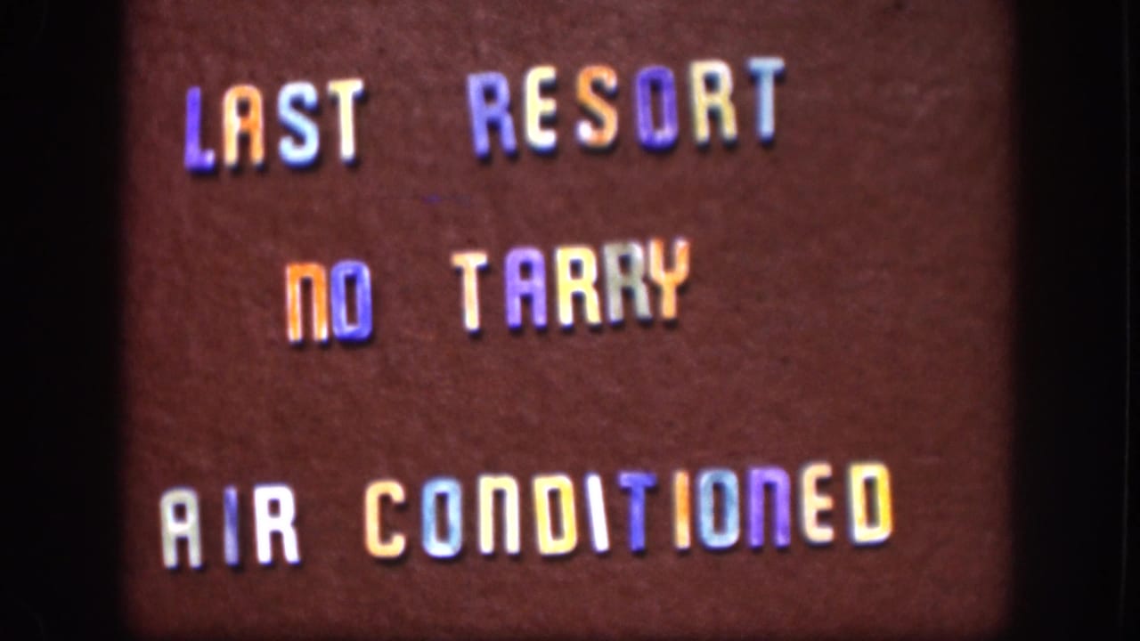1958 Kansas 8mm close-up of a roadside establishment sign reading 'LAST RESORT / NO TARRY / AIR CONDITIONED' with characteristic chromatic color shift on aged film.