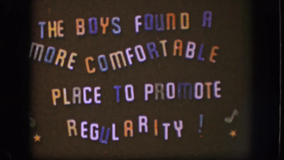 1958 home-movie title card with multicolored hand-lettered humor text, musical note symbols, and yellow star decorations on a dark background.