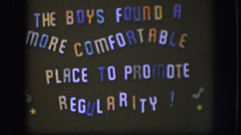 8mm home-movie title card circa 1958, Kansas, with multicolored all-caps lettering, musical note symbols, and yellow stars on a dark background.