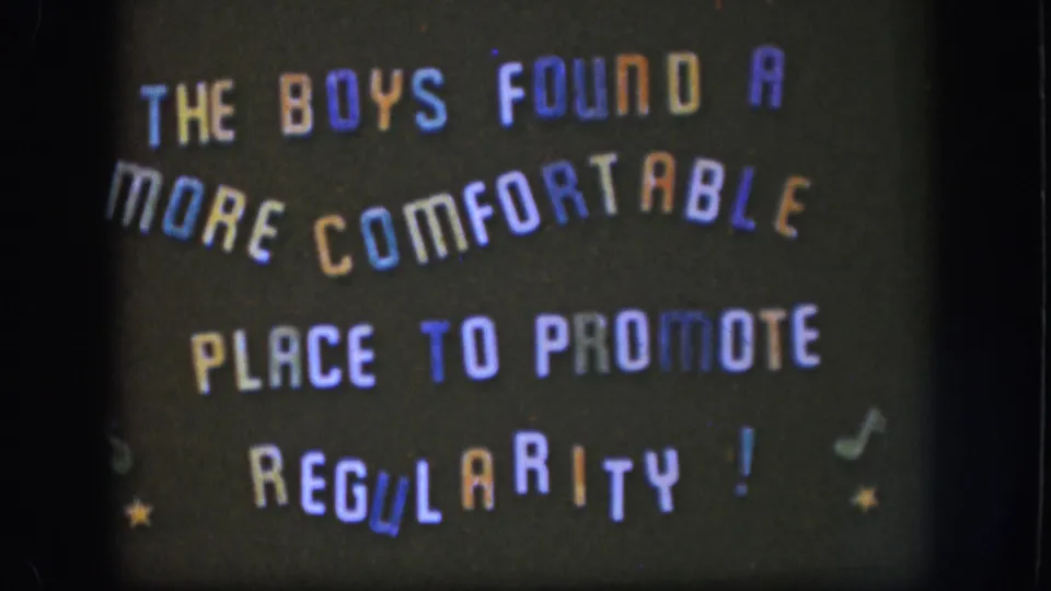 Closing frame of 1958 Kansas 8mm title card with multicolored all-caps text, star and musical note decorations, and visible film grain and border.
