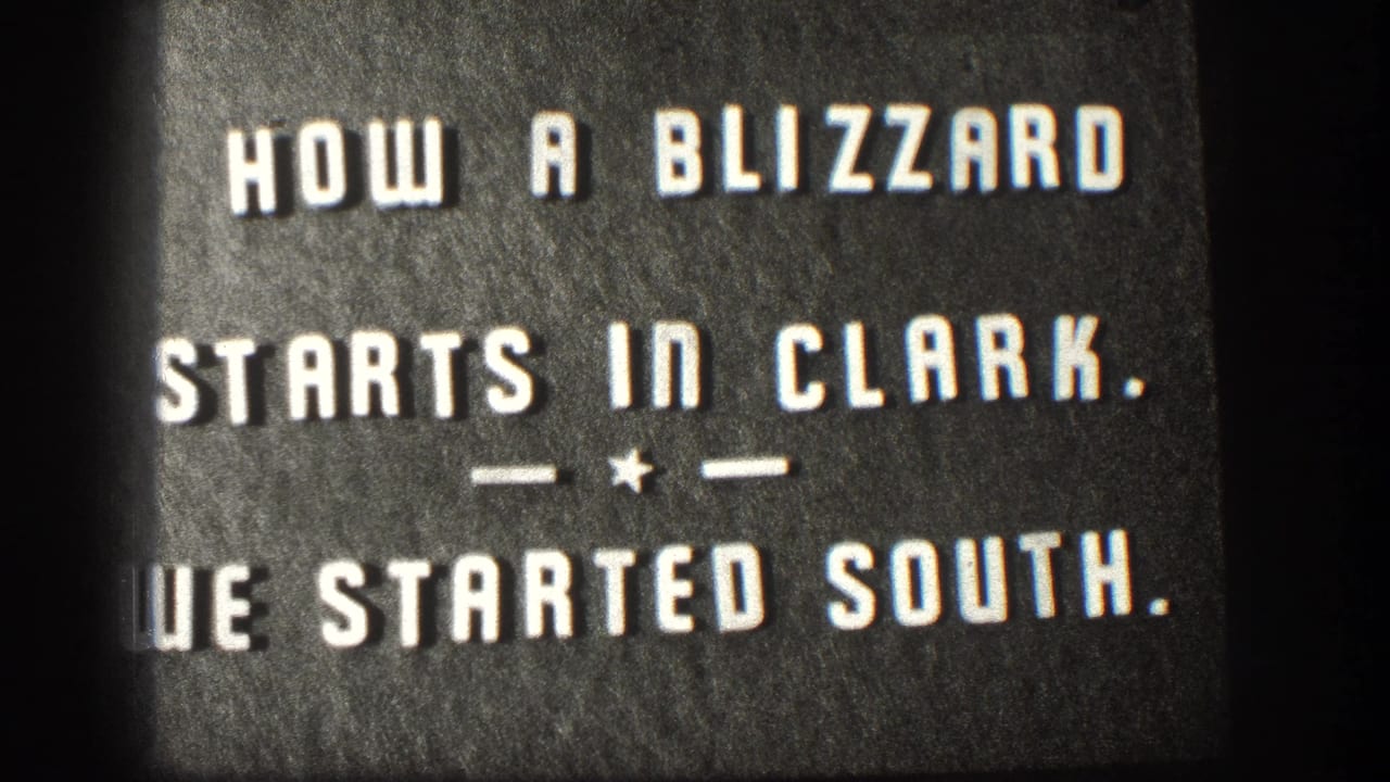 8mm intertitle card from a 1958 Kansas home movie reading 'HOW A BLIZZARD STARTS IN CLARK. — * — WE STARTED SOUTH.' on dark background.