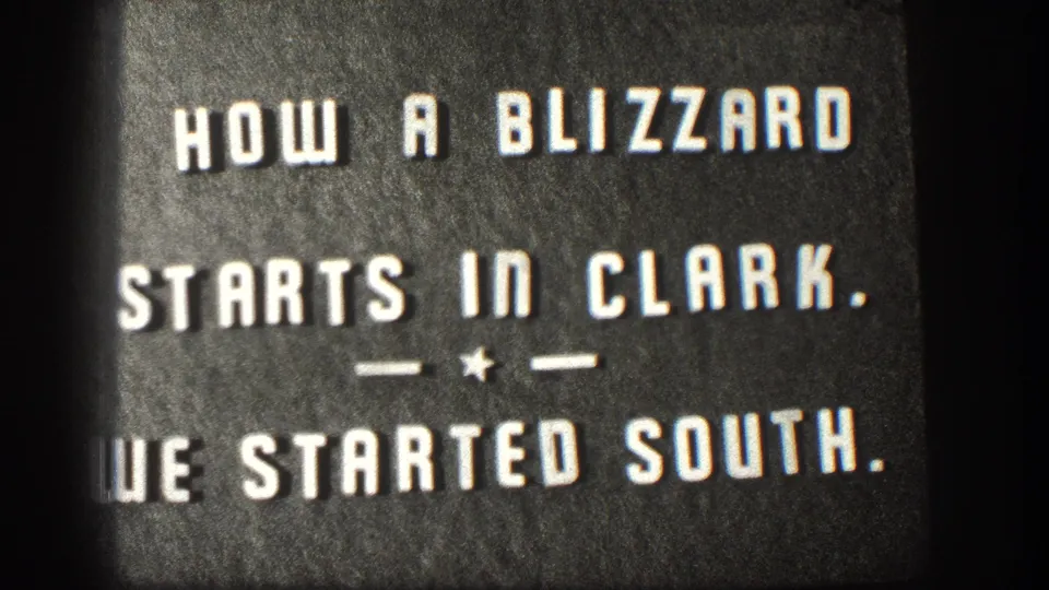 8mm home movie intertitle, second hold of the same card reading 'HOW A BLIZZARD STARTS IN CLARK.' from a 1958 Kansas blizzard sequence.