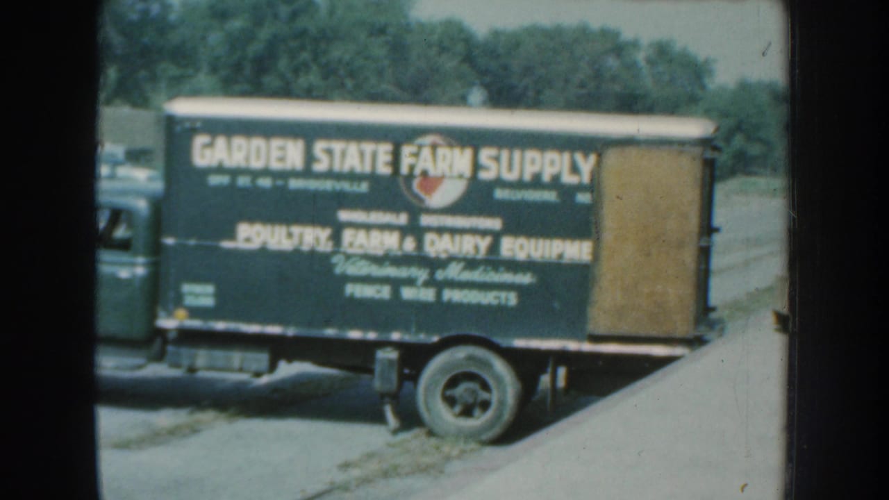 1959 Nebraska 8mm frame showing a Garden State Farm Supply delivery truck with farm and dairy equipment lettering.