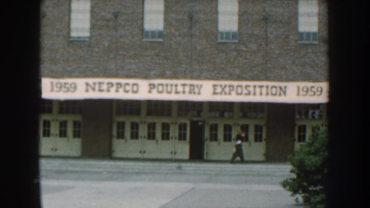 Brick venue facade with exposition banner and a person walking past the doorway.