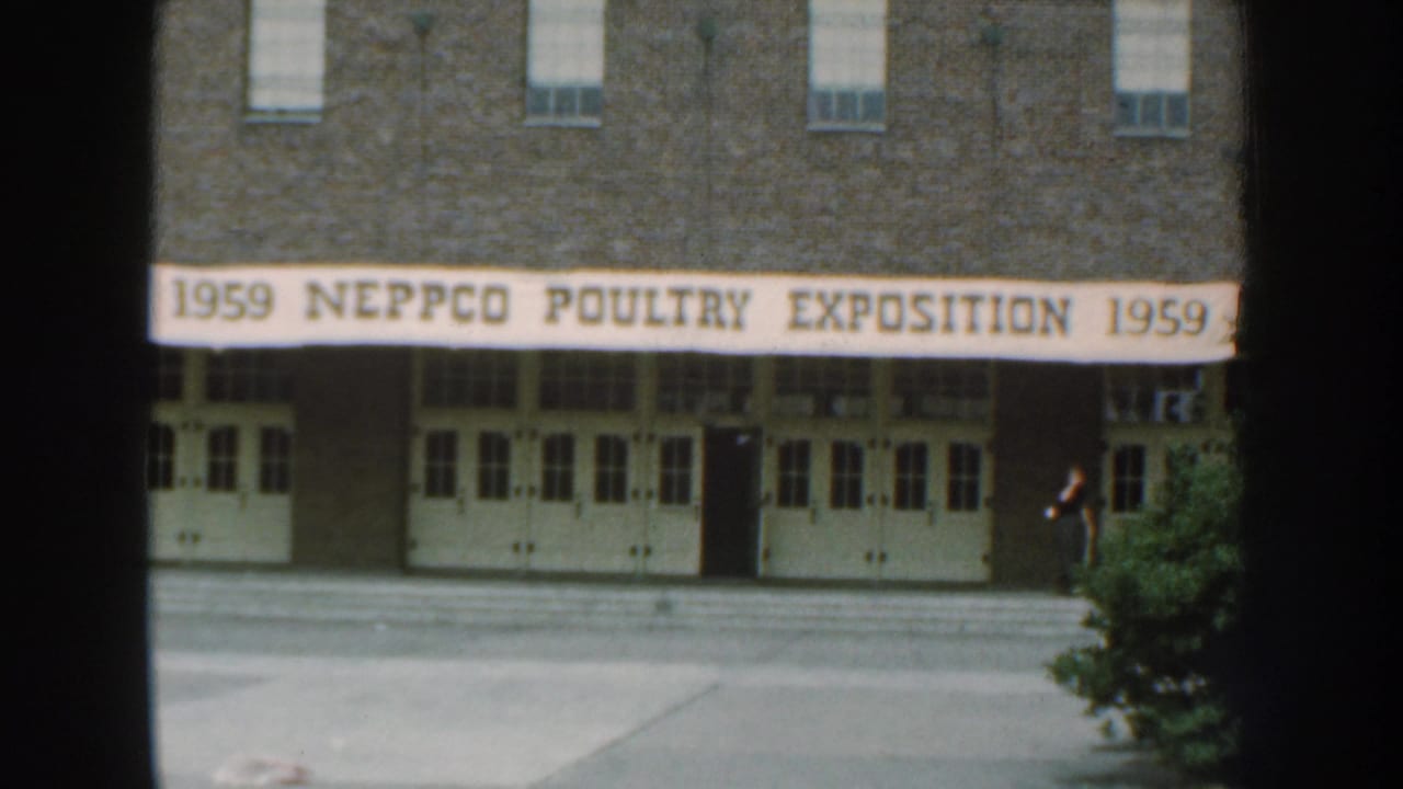 1959 Nebraska exterior view of a brick building with a NEPPCO Poultry Exposition banner over white doors.