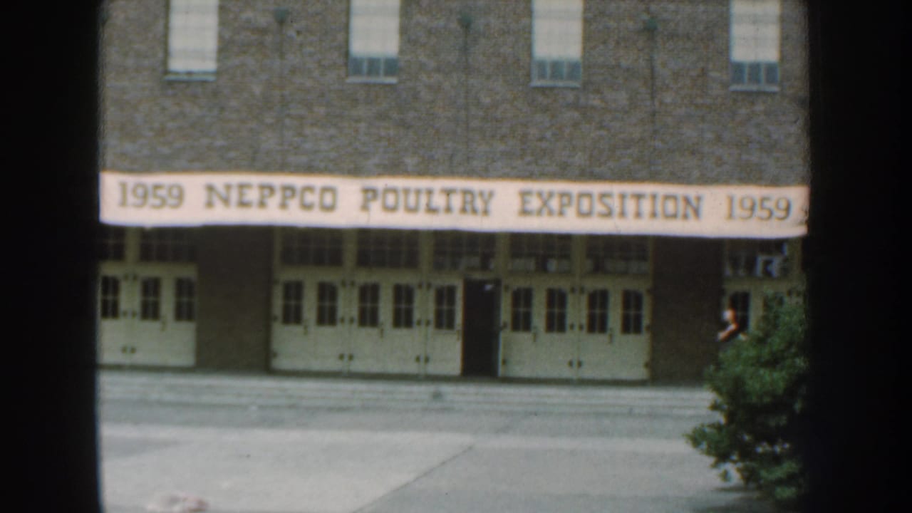 Exposition entrance with banner and a man near the right side of the building.