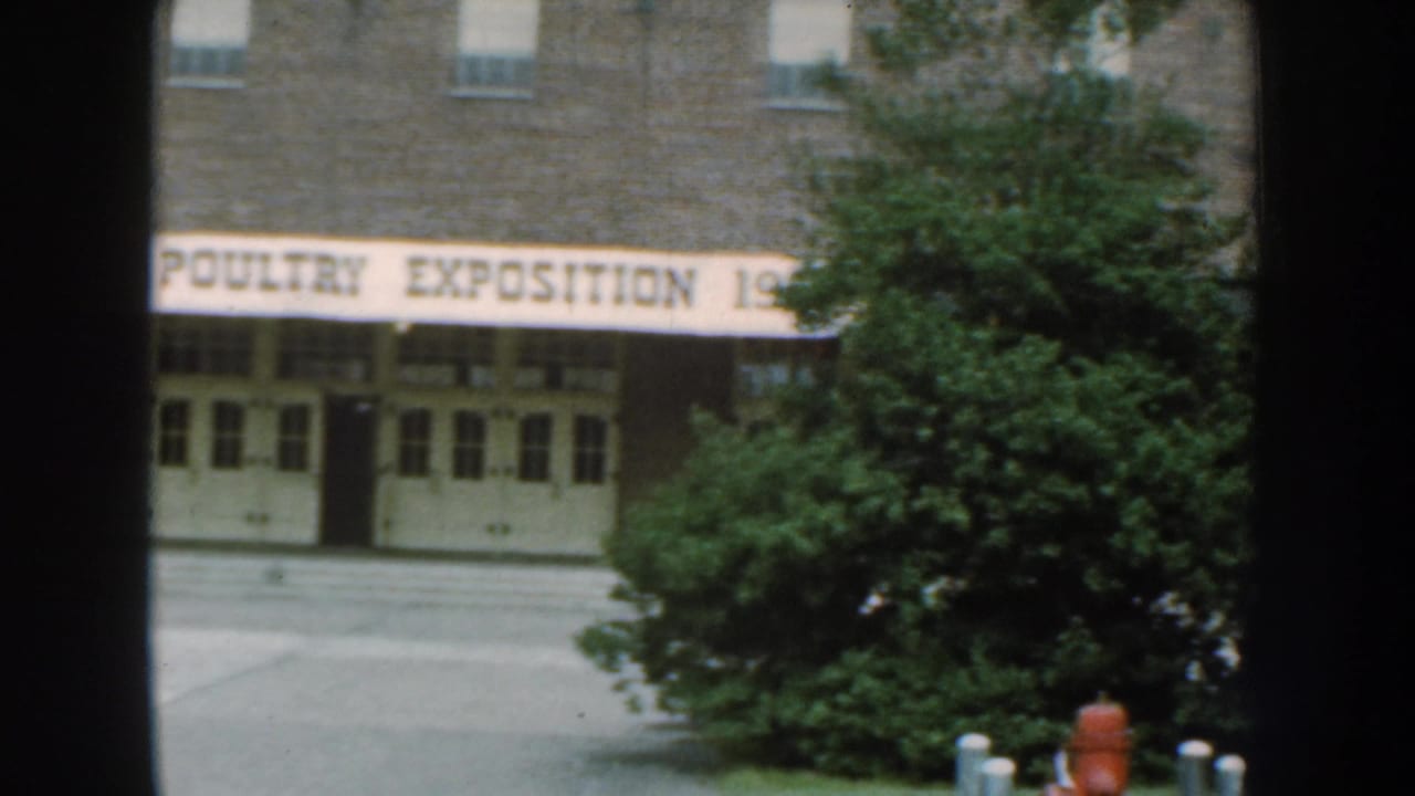 1959 Nebraska exterior view of the NEPPCO Poultry Exposition building, with the banner crossing the facade and trees at right.