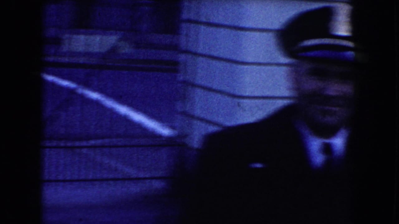 A uniformed security officer appears near a stone facade and metal railings in Washington, D.C. footage.