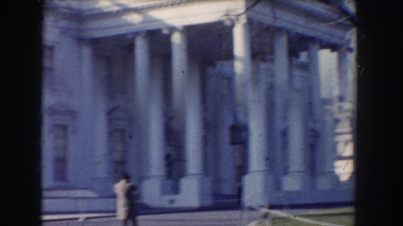 Grand columned building facade with a distant pedestrian near the entrance.