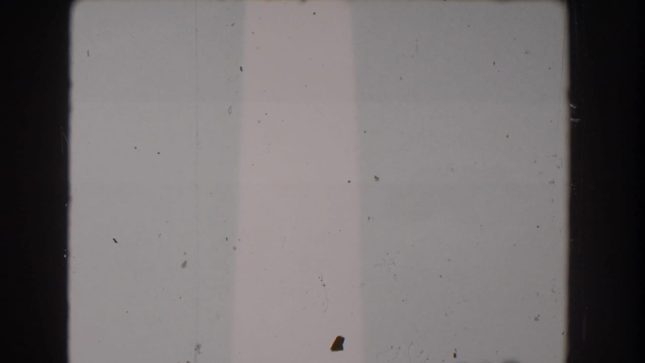 Mostly pale sky with a narrow edge of the monument and film dust.