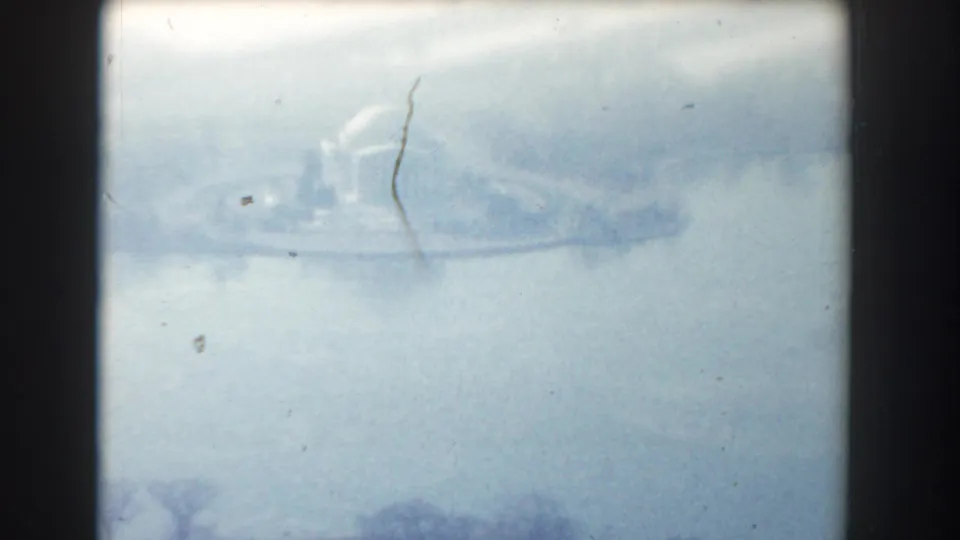 1960 Washington, DC 8mm frame showing a hazy aerial view over water toward a domed memorial-like building and shoreline.