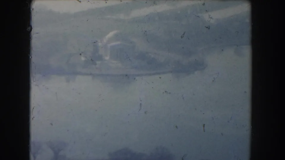 Faded 8mm aerial view in Washington, DC, with a domed memorial-like form near water under heavy haze.