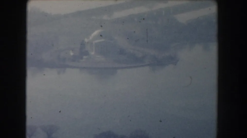 1960 Washington, DC home-movie frame with a soft aerial view of a domed memorial-like building by water and trees.