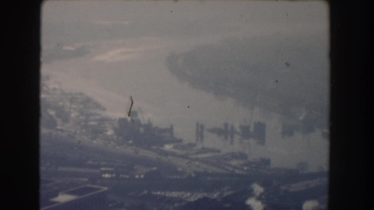 Soft aerial view over Washington, DC with water, bridges, and distant monument area.