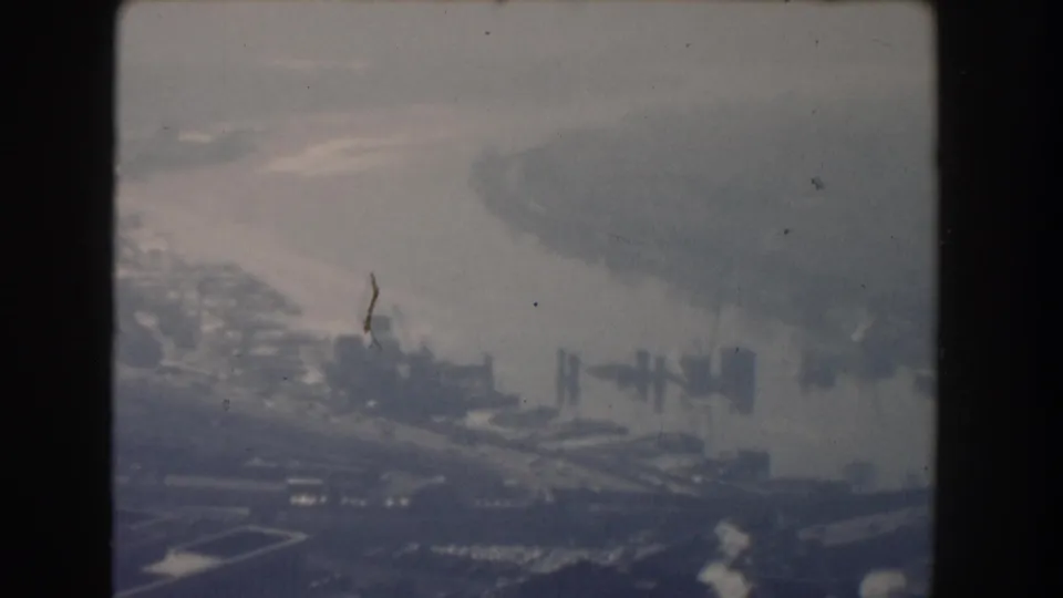 1960 Washington, DC 8mm aerial view with river water, bridges, parkland, and a hazy view toward the National Mall area.