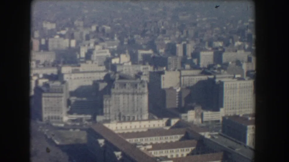 1960 Washington, DC aerial view showing dense mid-century blocks, broad streets, and large government-scale buildings through haze.