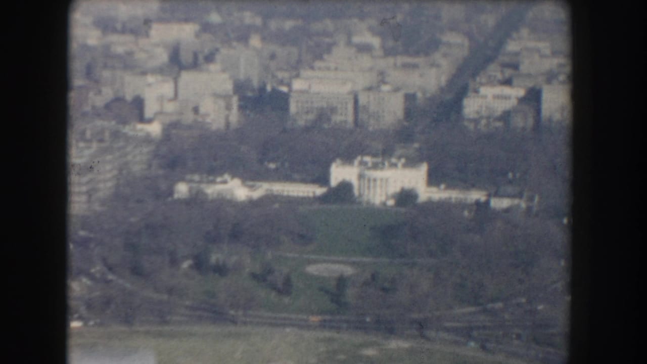 Aerial view of the White House grounds with surrounding Washington buildings.