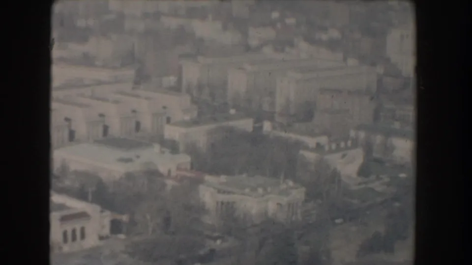 1960 Washington, D.C. aerial view showing rooftops, wide streets, and government-area buildings in soft 8mm color.